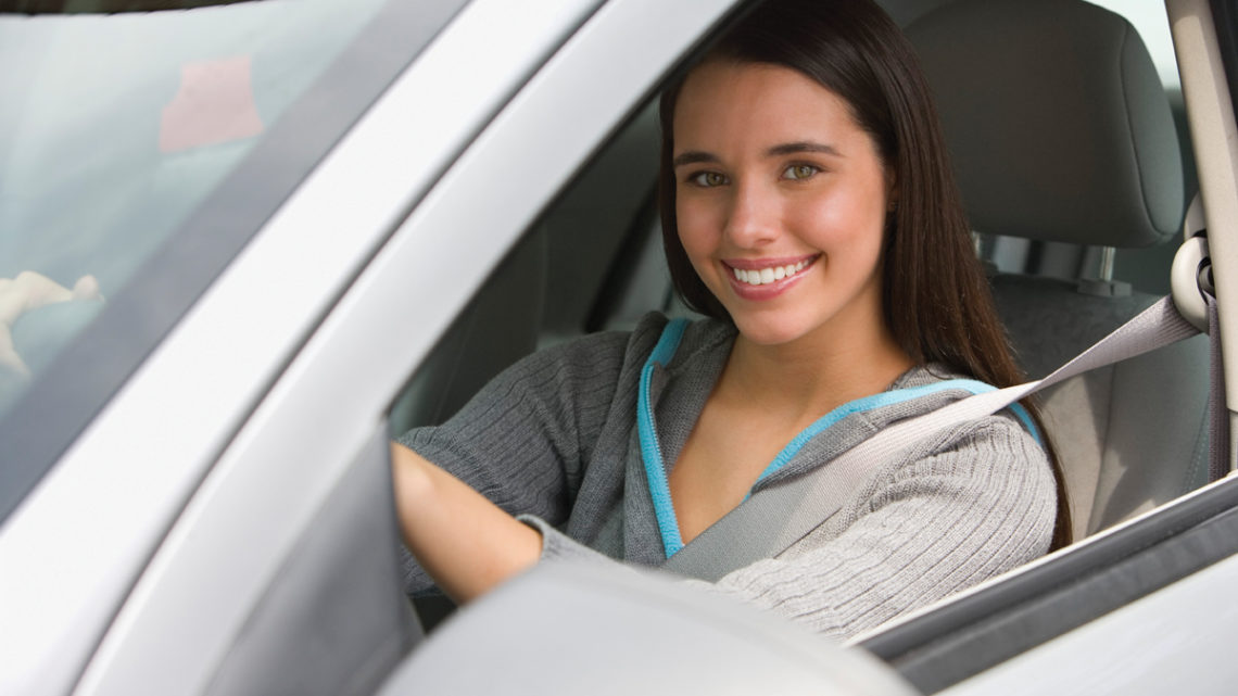 Portrait of teenage girl smiling in car